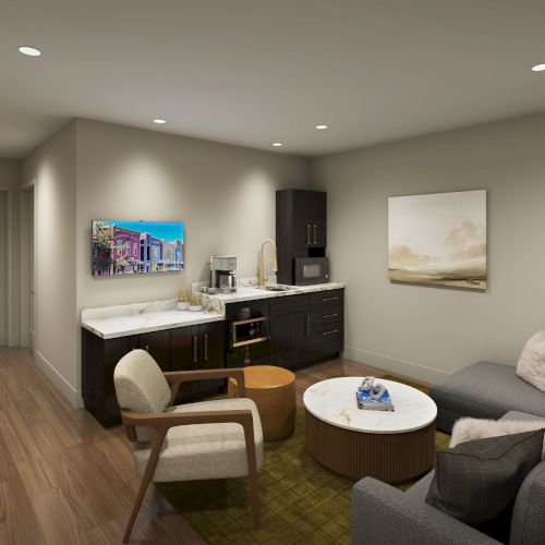 The image shows a modern living room with a sofa, armchair, round coffee table, and a kitchenette in the background.