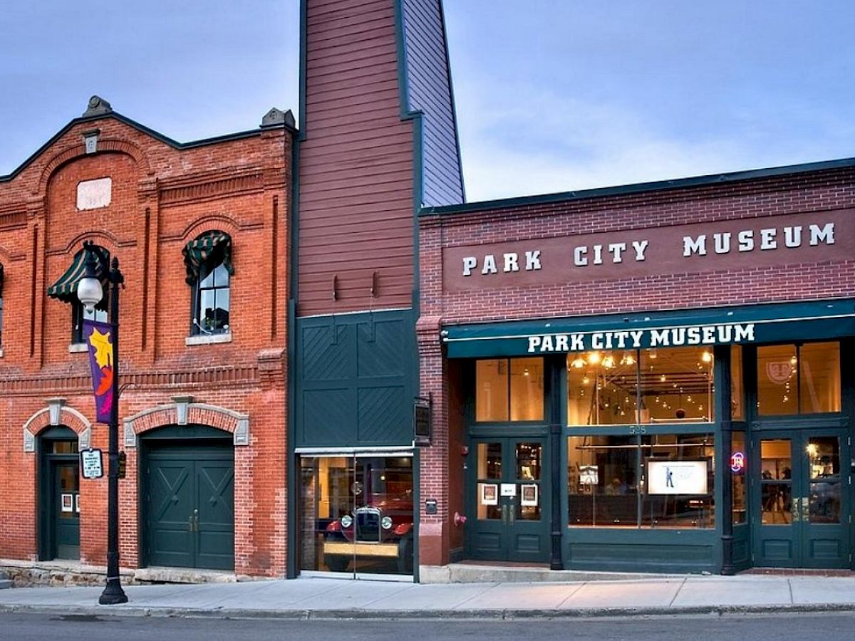 The image shows the Park City Museum, a brick building with a large entrance, located on a street with a lamppost.