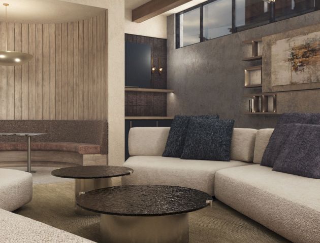 A modern living room with a beige sectional sofa, dark accent pillows, round coffee tables, and wood-and-concrete wall decor.