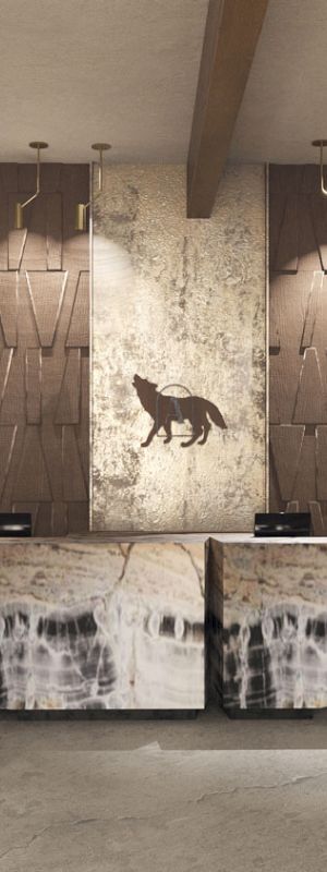 Modern interior lobby with a central reception desk, warm pendant lights, and wall art featuring a black dog.